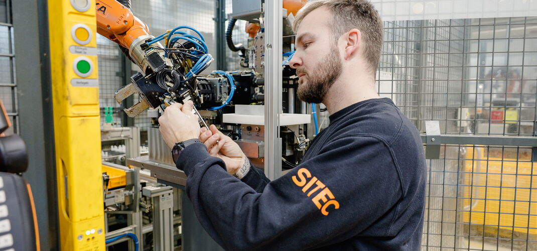 Ein Servicetechniker führt eine Wartung an einem Roboterarm durch